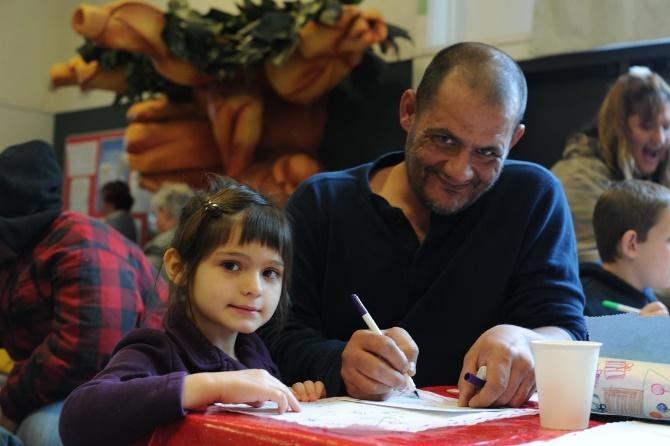 Hailey, 6, and her father Joseph Rogers draw on a thank you card for Santa Claus Dec. 20, 2016, at Cedar Lane Elementary School in Olivehurst, California. The Rogers family was one of 51 homeless families invited to Breakfast with Santa for the Marysville Joint Unified School District’s homeless students and their families. (U.S. Air Force photo by Senior Airman Tara R. Abrahams)