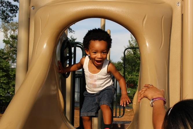 African American boy playing in a slide.